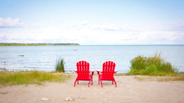 two chairs by the water's edge on a lake