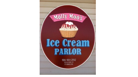 Molly Moo's Icre Cream Parlor sign on the wall. Picture of cupcake in the center.
